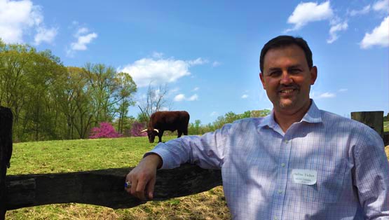 Dee Brown in front of a Red Devon Cow
